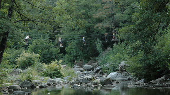 Famille traversant un pont au-dessus d'une rivière