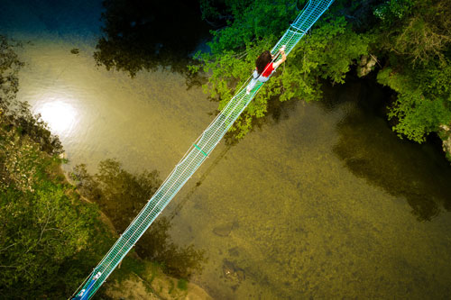 Un pont suspendu au-dessus de la rivière vu du ciel